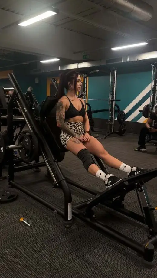 Sylwia training legs on a hack squat machine